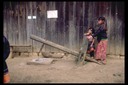 Hmong girls operating corn pounder, Mae Sa Mai, Thailand, 1986